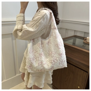 Detail showing the textured jacquard fabric with purple butterfly patterns on a tote bag