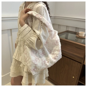 Detail of canvas tote bag with pink butterfly prints and stylish frayed edge design