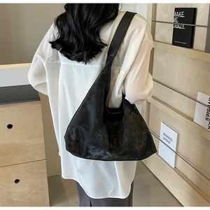 Détail du grand sac hobo noir en cuir montrant sa texture naturelle et sa forme souple