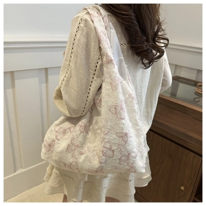Macro view of cream tote bag with pink butterfly jacquard fabric and soft fuzzy texture