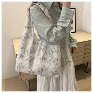 Detail of soft jacquard tote bag with butterfly embroidery shown in daily scene