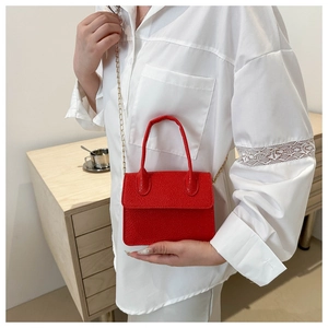 Détail du mini sac à main rouge texture litchi avec bandoulière chaîne dorée