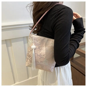 Detail of silk satin bucket bag with traditional floral embroidery and white tassel
