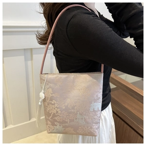 Detail of pink brocade bucket bag with traditional landscape pattern and white tassel