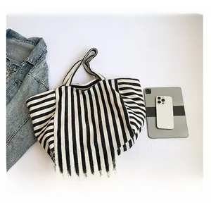 Vertical striped canvas tote bag showing interior capacity with tablet for scale