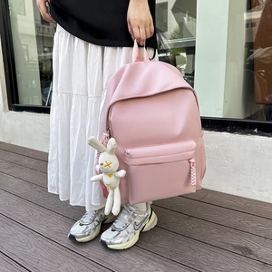 Pink minimalist waterproof nylon backpack for students featuring cute rabbit charm decor