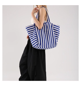 Detail of blue and white striped canvas tote bag with wide matching shoulder strap