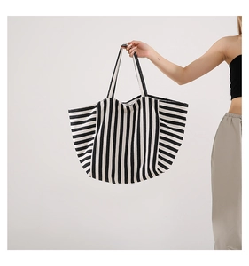 Detail of the high-capacity striped tote bag with durable black handles and canvas texture