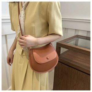Caramel saddle bag with a smooth finish and a round button closure for women