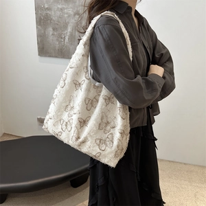 Chic jacquard butterfly shoulder bag with fringe edges on a model in ivory white