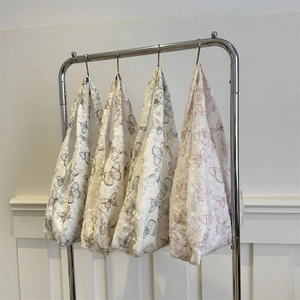 Fashionable floral butterfly jacquard tote bags in four colors on a silver metal rack