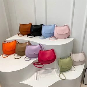 Chic candy-colored saddle crossbody bags in 10 vibrant colors displayed on white steps