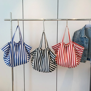 Vertical striped canvas tote bags in blue, black, and red with a spacious trapezoid design