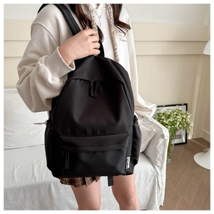 Detailed side view of black fashion backpack with side pockets and FASHION label detail