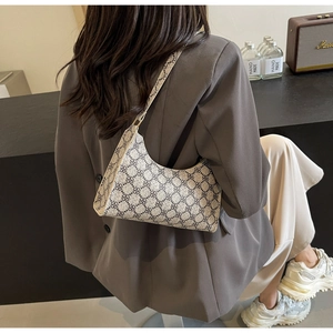 Dettaglio della borsa sottobraccio vintage con stampa geometrica e tracolla chic