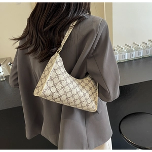 Dettaglio della borsa hobo con motivi floreali marroni sulla tracolla beige