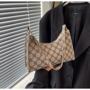 Dettaglio della borsa hobo con motivo a trifoglio retrò e fibbia dorata sulla tracolla