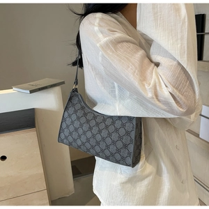 Dettaglio della borsa a spalla a mezzaluna grigio scuro con motivo a trifoglio su camicia