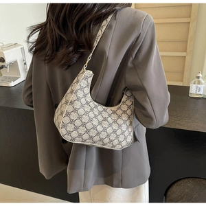 Detail view of the vintage hobo bag with dark clover print and sleek shoulder strap