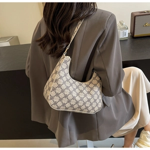 Detail of vintage crescent hobo bag with grey geometric patterns worn over shoulder