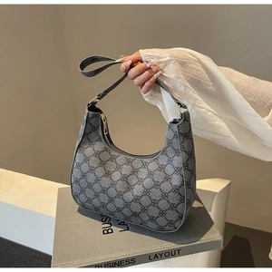Detail of grey crescent hobo bag with black quatrefoil pattern and gold zipper hardware