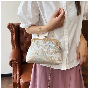 Dettaglio borsa a conchiglia in jacquard vintage con ricamo oro e chiusura in metallo