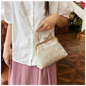 Dettaglio dell'elegante borsa jacquard con ricamo di paesaggio e cornice dorata
