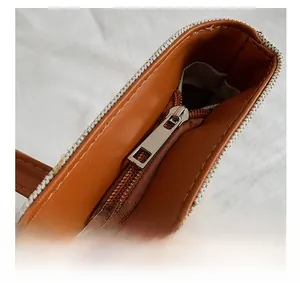 Detail of the high-quality zipper closure and brown faux leather trim on a canvas tote bag