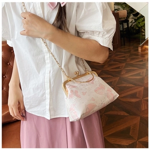 Dettaglio della borsa a conchiglia vintage in jacquard con farfalle rosa e catena metallica