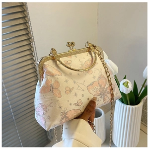 Dettaglio della borsa a conchiglia jacquard con motivi a farfalla rosa e chiusura dorata