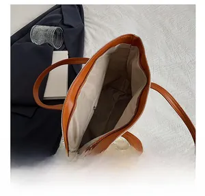 Top view of the interior compartment showing zipper pocket and cream canvas tote bag details
