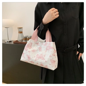 Vue détaillée du sac cabas blanc avec imprimés papillons roses et anses ruban