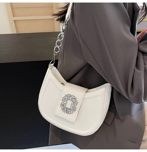 Detailed close-up of a white Hobo bag with a large crystal buckle and silver chain strap