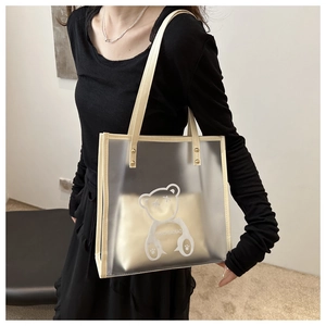 Detail of transparent PVC tote bag featuring a cute cartoon bear print and inner pouch