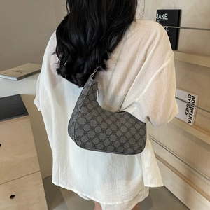 Retro grey crescent underarm bag with geometric clover pattern shown on a shoulder