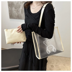 Detail of transparent PVC tote bag with white bear print and inner cream pouch bag