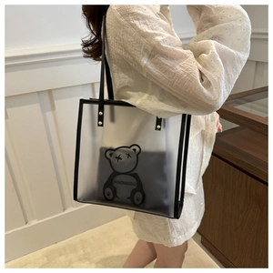 Detail view of transparent PVC tote bag with cartoon bear and black inner pouch