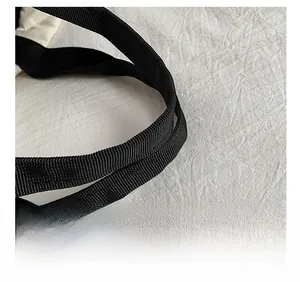 Close-up of comfortable black nylon shoulder strap on a white quilted diamond tote bag