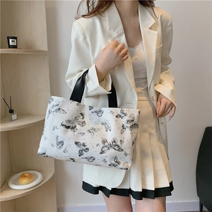 Grand sac cabas blanc élégant avec imprimés papillons noirs et anses raffinées