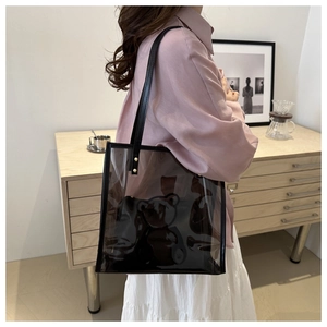 Macro view of transparent PVC tote bag with bear print and black leather handle