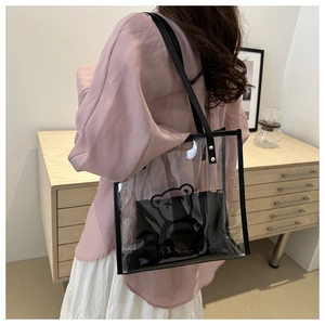Detailed view of transparent PVC tote bag with bear print inner pouch and shoulder strap