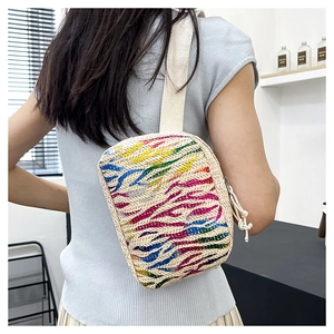 Détail du sac bandoulière en paille arc-en-ciel avec sangle en toile pour voyage d'été