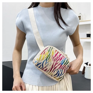 Détail du sac bandoulière en paille tressée aux rayures arc-en-ciel colorées