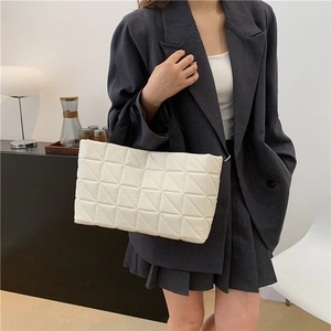 White quilted tote bag with geometric stitching and black handles for commute