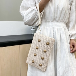 Beige woven crossbody bag with vintage copper rivets and white leather wrist strap