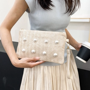 Beige woven clutch bag with white pearls and wristlet strap for summer leisure