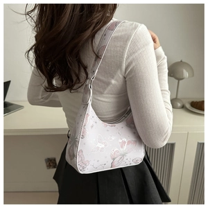 Detail of light purple hobo bag with pink butterfly and star prints on a shoulder strap