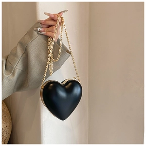 Dettaglio della borsa nera a forma di cuore con cornice in metallo dorato e catena