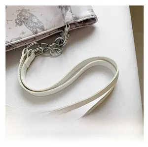 Detail van de crème PU-schouderriem met zilveren metalen ketting en sterrenprint