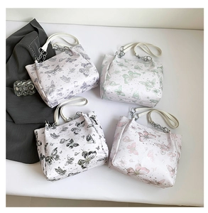 Bovenaanzicht van kleurrijke tote bags met vlinderprint en metalen kettingen in vier kleuren